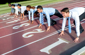 Competitive business people running at the track